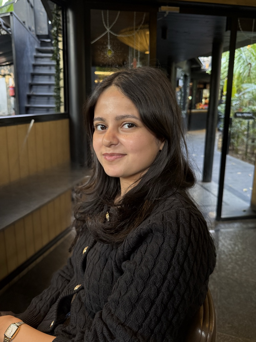 Ridhi smiling at a cafe